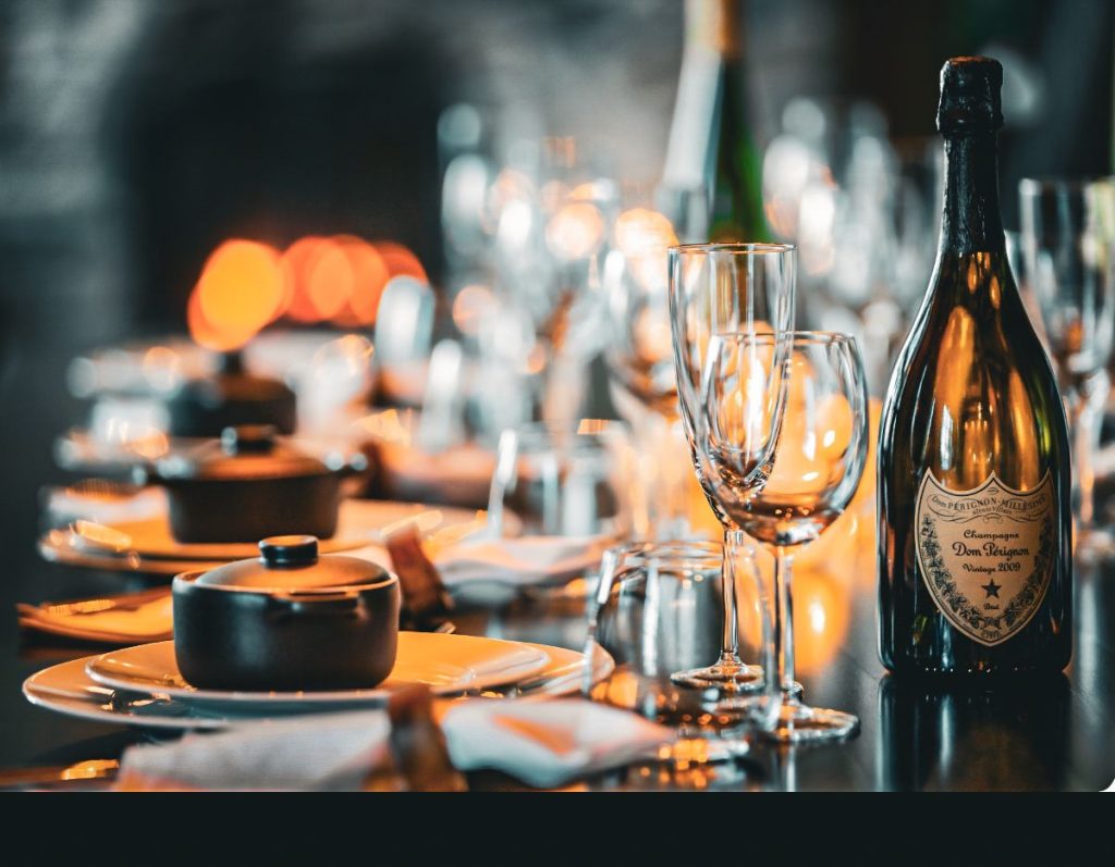 A candlelit dining table set with elegant dishes and fine wine, surrounded by the calm of the Arctic wilderness