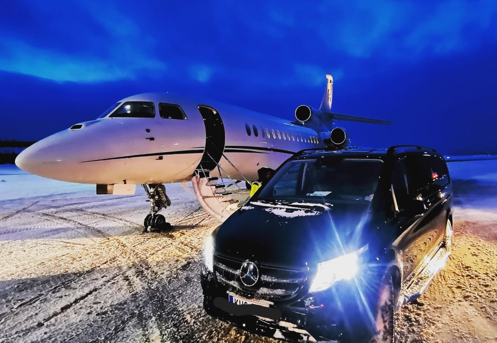 A private jet and a black Mercedes Vito parked side by side, symbolizing seamless luxury transfer